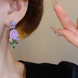 Eleganti orecchini pendenti a rosa viola stile pastorale con strass e foglie verdi su modella