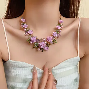 Primo piano di una collana di perle a fiori pastorali con strass viola su modella