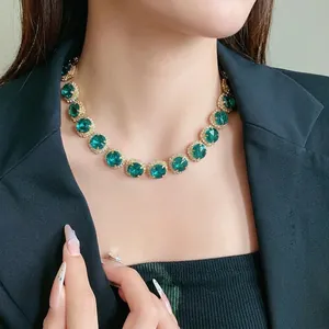 Elegant emerald green crystal statement necklace with sparkling gold-plated rhinestone setting.