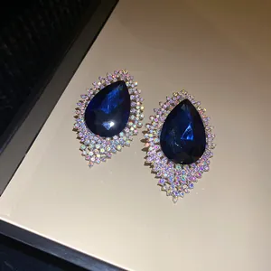 Exquisite close-up of blue teardrop stud earrings with a sparkling rhinestone halo