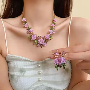 Vista dettagliata della collana e degli orecchini con fiori di resina viola e perle
