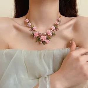 Collana floreale in stile pastorale con rose rosa, perle e strass su una modella.