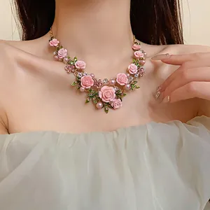 Vista dettagliata della collana pastorale di rose rosa con perle e cristalli su una modella