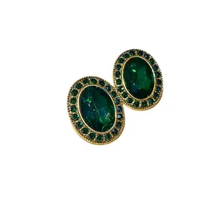 Elegant vintage royal style oval green gemstone stud earrings with a gold-tone finish.
