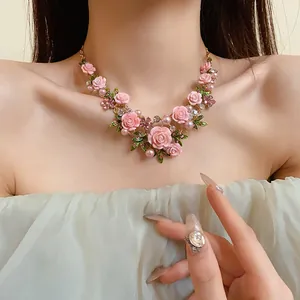 Dettaglio della collana di rose rosa pastorali con perle e strass scintillanti sul collo