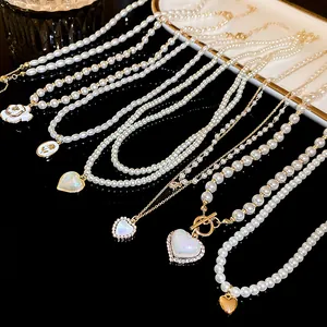 Detailed view of mermaid luster pearl necklaces with various heart and floral pendants