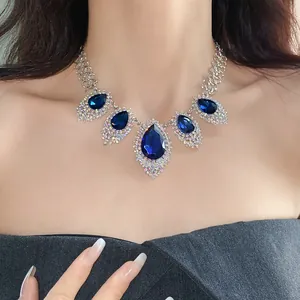 Detail view of an elegant silver necklace featuring sapphire blue teardrop stones