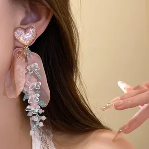 Dettaglio degli orecchini a cuore con petali in chiffon rosa e nappe di perline