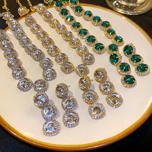 Detailed view of geometric rhinestone necklace and earring sets in silver and gold