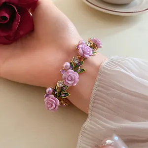 Dettaglio del braccialetto floreale con rose viola, perle e strass scintillanti