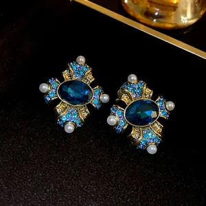 Detailed macro view of vintage palace style blue gemstone earrings with white pearls.