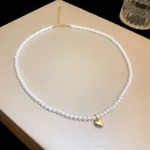 Elegant French style pearl necklace with a polished gold heart pendant close-up