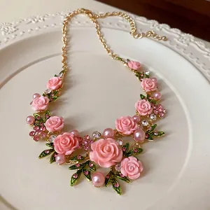Dettaglio macro di una collana con rose rosa in stile pastorale con strass e perle