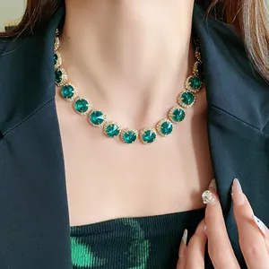 Close-up of luxury emerald green crystal choker necklace with pavé diamond borders