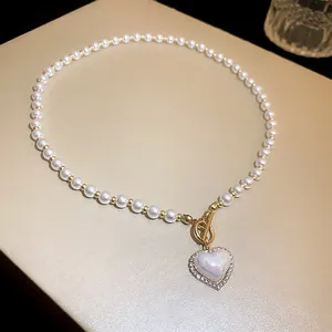Close-up of mermaid heart pearl necklace with rhinestone border and gold toggle clasp