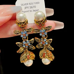 Detail view of vintage-style earrings featuring colorful crystal stones and pearls