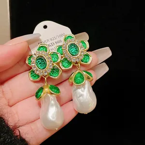 Detailed close-up of vintage court style earrings with green enamel and baroque pearls