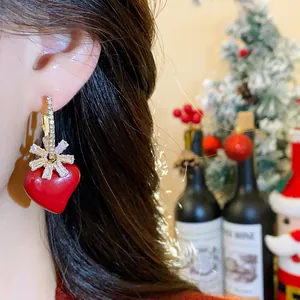Détail d'un mannequin portant une boucle d'oreille cœur rouge plaqué or 18 carats.