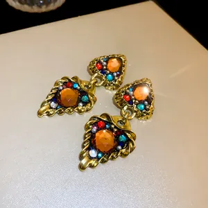 Macro view showing the intricate detail of vintage palace style gold earrings with colorful gemstones