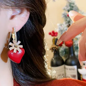 Gros plan sur des boucles d'oreilles cœur rouge plaquées or 18 carats avec zircon
