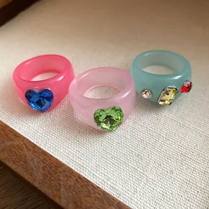 Close-up of colorful resin rings with heart-shaped and geometric crystal inlays