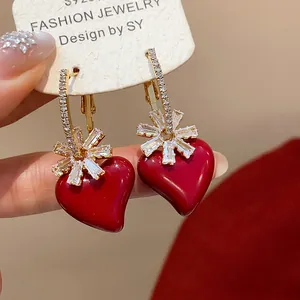 Vue détaillée des boucles d'oreilles cœur rouge plaquées or 18 carats avec fleurs en zircon