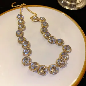 Close-up of luxury geometric rhinestone necklace in golden setting for formal dresses.