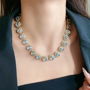 Detailed view of high-end rhinestone necklace on model with elegant black blazer jacket