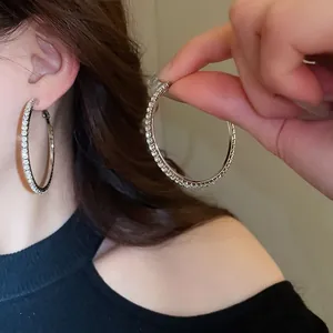 Macro view of large silver hoop earrings encrusted with sparkling round crystals