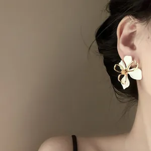 Detailed close-up of a French vintage floral earring with gold metal outline on ear
