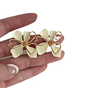 Vintage French cream floral stud earrings with gold accents and silver needle posts.