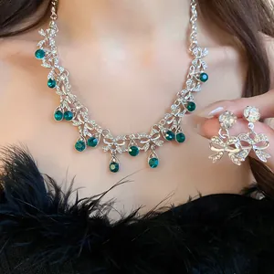 Detailansicht eines Vintage-Schmucksets mit Schleifen und eleganten smaragdgrünen Strasssteinen