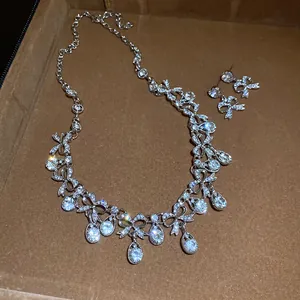 Detailansicht eines funkelnden silbernen Schmucksets mit Schleifen und Kristalltropfen.