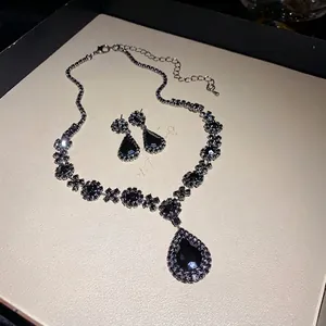 Luxury black waterdrop crystal necklace and earring set with rhinestone embellishments.