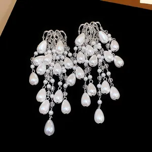 Close-up detail of French palace style teardrop tassel pearl earrings with silver needles