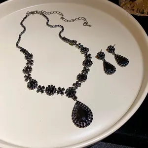 Elegant black rhinestone necklace and earring set with teardrop pendant on tray