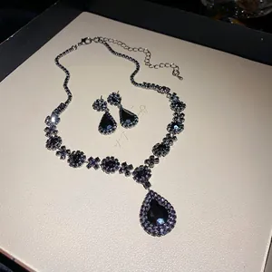 Detailed macro view of black rhinestone water drop pendant necklace and earrings set