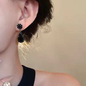 Detailed close-up view of elegant black teardrop earrings with shimmering rhinestone accents