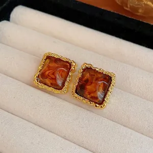 Vintage square stud earrings with amber marbled resin and gold textured frame