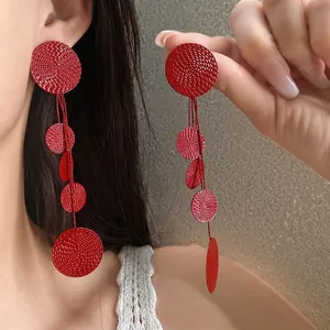 Elegant red textured round tassel drop earrings with long dangle design for women.