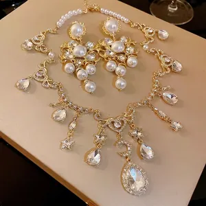 Elegant vintage pearl necklace and earring set featuring rhinestone heart and moon pendants.