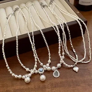 Gros plan de colliers de perles de style rétro français avec pendentifs cœur et zircon
