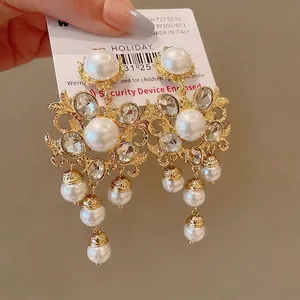 Vintage baroque style ornate gold earrings with white pearls and sparkling rhinestones