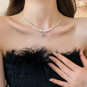 Détail d'un collier de perles vintage avec pendentif goutte d'eau bleue sur mannequin