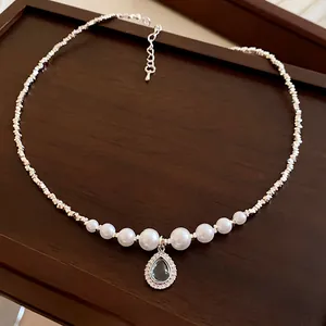 Vue détaillée d'un collier de perles vintage français avec pendentif larme bleu clair.