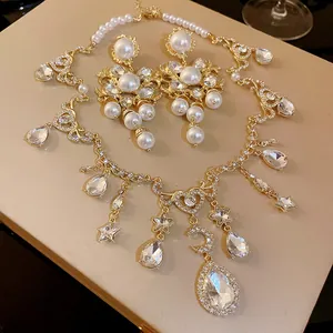 Detailed view of vintage rhinestone pearl necklace and earrings with heart moon pendants