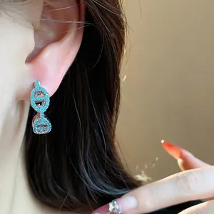 Retro pig nose earrings with blue zircons worn by a model in a close-up view