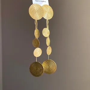Elegant gold long tassel earrings with textured circular discs for a chic luxury look.