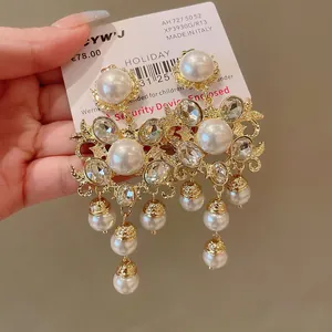 Close-up of vintage gold chandelier earrings with elegant pearls and shiny rhinestones