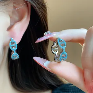 Macro view of vintage pig nose earrings with blue zircon stones and silver finish